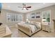 Spacious main bedroom features plantation shutters, a ceiling fan, and decorative paintings at 13918 Old Creek Ct, Parrish, FL 34219