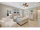 Spacious main bedroom features plantation shutters, a ceiling fan, and seating area at 13918 Old Creek Ct, Parrish, FL 34219