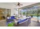 Cozy outdoor living area featuring comfortable seating, a ceiling fan, and a summer kitchen at 13918 Old Creek Ct, Parrish, FL 34219