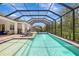 Stunning screened-in pool area with lounge chairs and outdoor kitchen, perfect for relaxation and entertaining at 13918 Old Creek Ct, Parrish, FL 34219