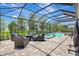 Screened-in lanai featuring a pool, outdoor seating area with plush cushions, and brick pavers perfect for entertaining at 13918 Old Creek Ct, Parrish, FL 34219