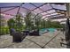 Screened-in lanai featuring a pool, outdoor seating area with plush cushions, and brick pavers perfect for entertaining at 13918 Old Creek Ct, Parrish, FL 34219