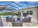 Outdoor lounge area featuring stylish wicker furniture, fire pit, screened-in pool, and beautiful patio under the lanai at 13918 Old Creek Ct, Parrish, FL 34219