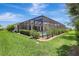 Inviting screened pool area with lush landscaping and a clear blue sky at 13918 Old Creek Ct, Parrish, FL 34219