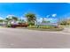 Canoe Creek community entrance with beautifully landscaped sign and palm trees at 13918 Old Creek Ct, Parrish, FL 34219