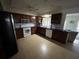 Bright kitchen with tile flooring, updated white appliances and dark wood cabinetry at 1500 Crest Dr, Englewood, FL 34223