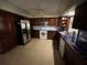 Bright kitchen with tile flooring, stainless appliances and dark wood cabinetry at 1500 Crest Dr, Englewood, FL 34223
