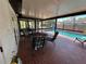 Screened outdoor patio with red brick flooring, table with chairs, and a view of the pool at 1500 Crest Dr, Englewood, FL 34223
