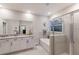 Bright bathroom featuring a granite countertop vanity and glass-enclosed shower and tub at 16807 Barnwood Pl, Bradenton, FL 34211