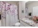 Cozy bathroom with a floral shower curtain, granite countertop, and ample lighting at 16807 Barnwood Pl, Bradenton, FL 34211