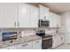 Modern kitchen features white cabinets, stainless steel appliances, and stylish granite countertops at 16807 Barnwood Pl, Bradenton, FL 34211