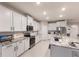Modern kitchen features white cabinets, stainless steel appliances, and granite countertops on a large island at 16807 Barnwood Pl, Bradenton, FL 34211