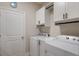 Efficient laundry room with white cabinets and modern washer and dryer at 16807 Barnwood Pl, Bradenton, FL 34211