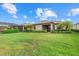 Spacious backyard with lush green lawn, tropical landscaping, and relaxing screened patio at 17018 Blue Ridge Pl, Bradenton, FL 34211