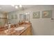Elegant bathroom with a marble countertop, seashell art, and a large mirror at 2045 Gulf Of Mexico Dr # M1-302, Longboat Key, FL 34228