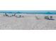 Wide sandy beach with turquoise umbrellas and chairs overlooking the ocean at 2045 Gulf Of Mexico Dr # M1-302, Longboat Key, FL 34228