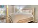 Comfortable bedroom featuring a queen bed, bi-fold closet door and neutral decor at 2045 Gulf Of Mexico Dr # M1-302, Longboat Key, FL 34228