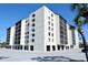 Exterior view of a modern condo building with screened lanais, parking and palm trees at 2045 Gulf Of Mexico Dr # M1-302, Longboat Key, FL 34228