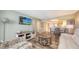 Open-concept living area with stylish furnishings, wood flooring, and a modern entertainment center at 2045 Gulf Of Mexico Dr # M1-302, Longboat Key, FL 34228