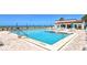 The sparkling pool is surrounded by lounge chairs and umbrellas for relaxation at 2045 Gulf Of Mexico Dr # M1-302, Longboat Key, FL 34228