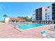 Community pool and lounging areas surrounded by lush landscaping at 2045 Gulf Of Mexico Dr # M1-302, Longboat Key, FL 34228