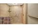 This remodeled shower features neutral tile, a built-in shelf and grab bars for safety at 2045 Gulf Of Mexico Dr # M1-302, Longboat Key, FL 34228