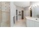Bright bathroom with a walk-in shower, double vanity, white cabinets, and marble floors at 2067 Tocobaga Ln, Nokomis, FL 34275
