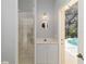 Light and airy bathroom featuring walk-in shower, a round mirror, and door to the pool at 2067 Tocobaga Ln, Nokomis, FL 34275