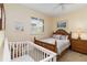 Cozy bedroom with a wicker bed, crib, and a shuttered window for natural light at 2067 Tocobaga Ln, Nokomis, FL 34275