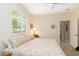 Well-lit bedroom with a neutral color palette, shuttered window, and ensuite bathroom at 2067 Tocobaga Ln, Nokomis, FL 34275