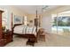 Bedroom with a four-poster bed and sliding glass doors overlooking a swimming pool at 2067 Tocobaga Ln, Nokomis, FL 34275