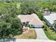 Aerial view of a well-maintained home with a three-car garage, lush landscaping and a paved driveway at 2067 Tocobaga Ln, Nokomis, FL 34275
