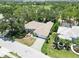 Aerial view of a well-maintained home with a three-car garage, lush landscaping and a paved driveway at 2067 Tocobaga Ln, Nokomis, FL 34275