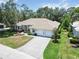 Aerial view of a well-maintained home with a three-car garage, lush landscaping and a paved driveway at 2067 Tocobaga Ln, Nokomis, FL 34275