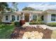 Beautiful beige home with manicured front lawn and shrubbery with a stone walkway at 2067 Tocobaga Ln, Nokomis, FL 34275