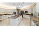 Bright kitchen featuring an island with barstool seating, stainless appliances, and custom cabinetry at 2067 Tocobaga Ln, Nokomis, FL 34275