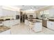 An open kitchen with white cabinets, stainless steel appliances, and a large center island with seating at 2067 Tocobaga Ln, Nokomis, FL 34275