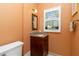 Cozy powder room featuring wood cabinet vanity, stained glass mirror, and window with blinds at 2067 Tocobaga Ln, Nokomis, FL 34275