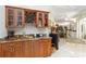 A wet bar with wood cabinets, granite counters, mini-refrigerator, and wine storage at 2067 Tocobaga Ln, Nokomis, FL 34275