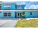 Beautiful blue home with landscaped front yard, updated windows, and double door entrance at 2100 Oyster Creek Dr, Englewood, FL 34224