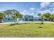 Beautiful blue two-story home featuring a well-maintained lawn, and tropical palm trees offering a serene and inviting curb appeal at 2100 Oyster Creek Dr, Englewood, FL 34224