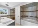 Well-lit main bathroom showcasing a bathtub, stand up shower, toilet, and sink with ample storage at 2100 Oyster Creek Dr, Englewood, FL 34224