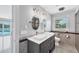 Beautifully updated main bathroom with dual sinks, stylish mirrors, and a view of the pool at 2100 Oyster Creek Dr, Englewood, FL 34224