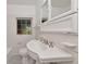Well-lit bathroom with a pedestal sink, decorative mirror, and classic black and white tile floor at 2620 8Th N Ave, St Petersburg, FL 33713