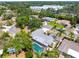 Expansive aerial view of a home featuring a screened-in pool nestled among lush trees at 2726 Silver King Way, Sarasota, FL 34231