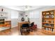 This bedroom has hardwood floors, a ceiling fan, a workspace, and a wooden bookcase at 2726 Silver King Way, Sarasota, FL 34231