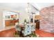 Cozy dining room with brick accent wall, view to the kitchen, and chandelier at 2726 Silver King Way, Sarasota, FL 34231