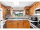 Bright kitchen features wood cabinets, granite countertops, and a window overlooking the front yard at 2726 Silver King Way, Sarasota, FL 34231