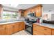 Traditional eat-in kitchen boasts wooden cabinetry, stainless appliances, and view of the front yard at 2726 Silver King Way, Sarasota, FL 34231