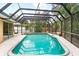 This screened pool is surrounded by a large patio with tropical foliage at 2726 Silver King Way, Sarasota, FL 34231